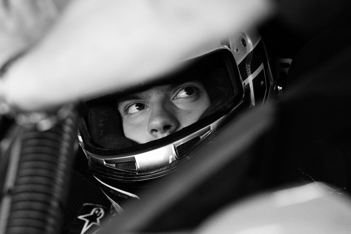 A young driver focused inside the helmet