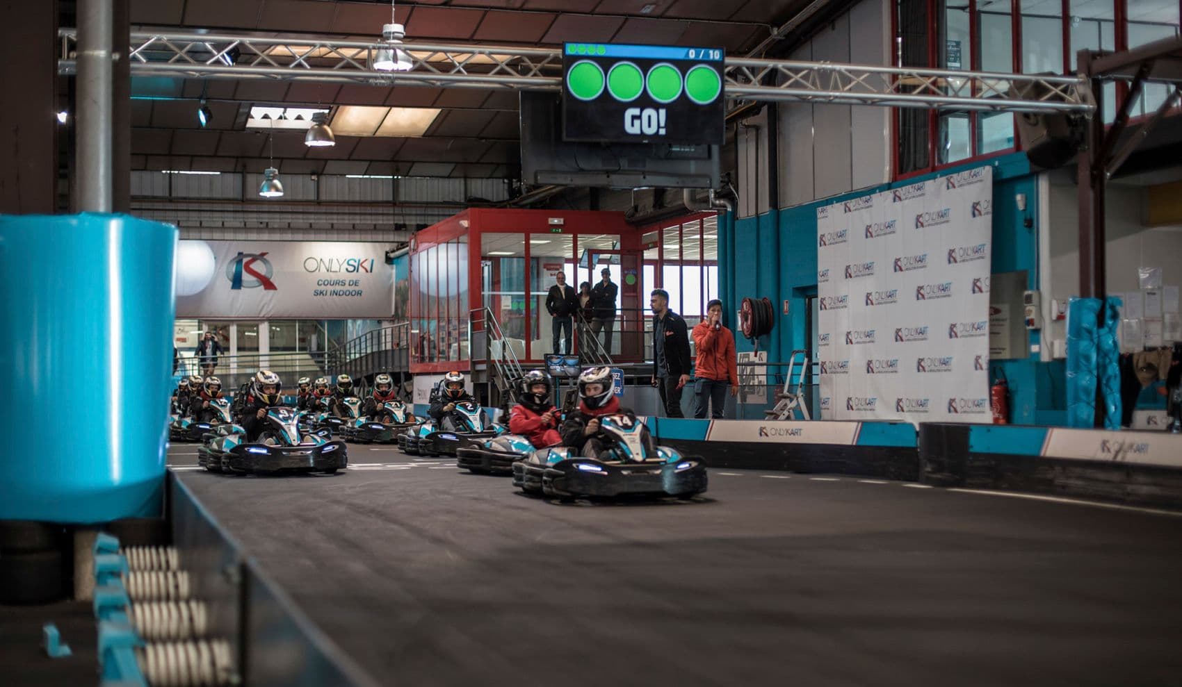 Karts staged under the start gantry at an indoor venue